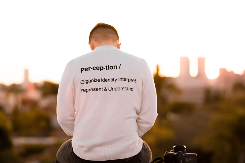 Picture of a man wearing a sweatshirt that says perception.